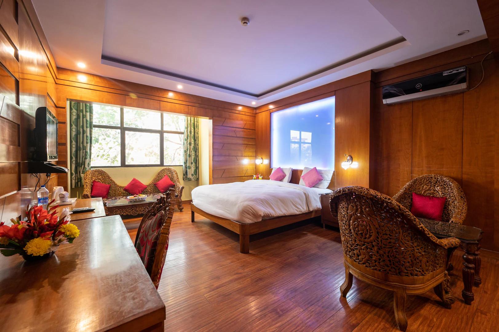 a double bed with sofa at emarald hotels resorts in new delhi hotel_Image
