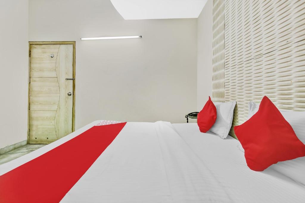 a bedroom with a large bed and red pillow at new crown continental in near sarai rohilla railway station hotel_Image