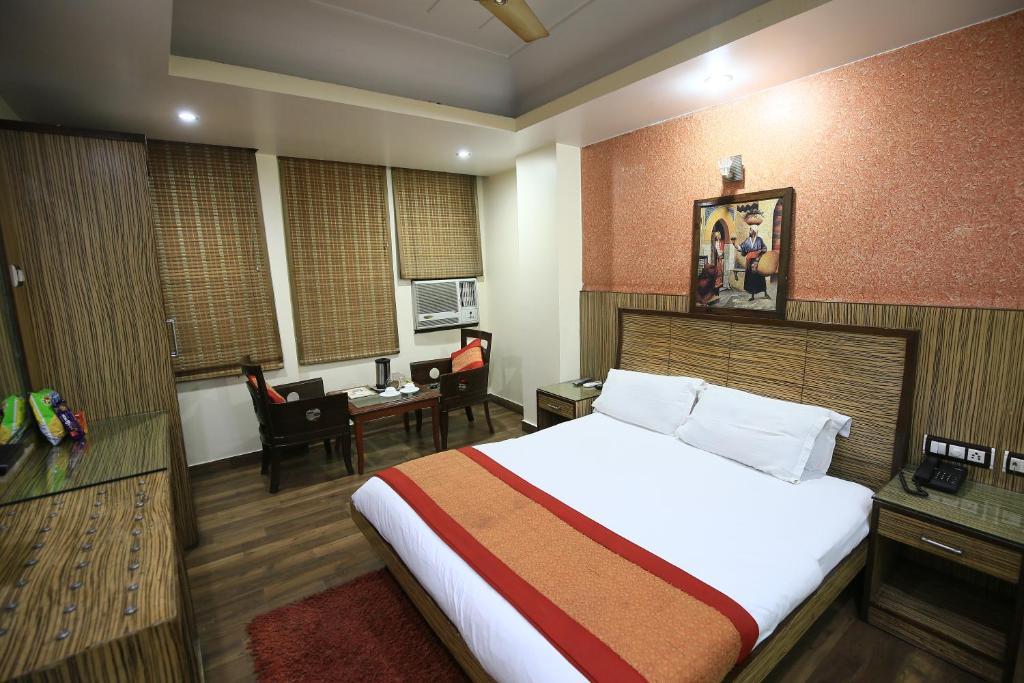 a bedroom with chairs and a tv at staybook shivdev in new delhi hotel_Image