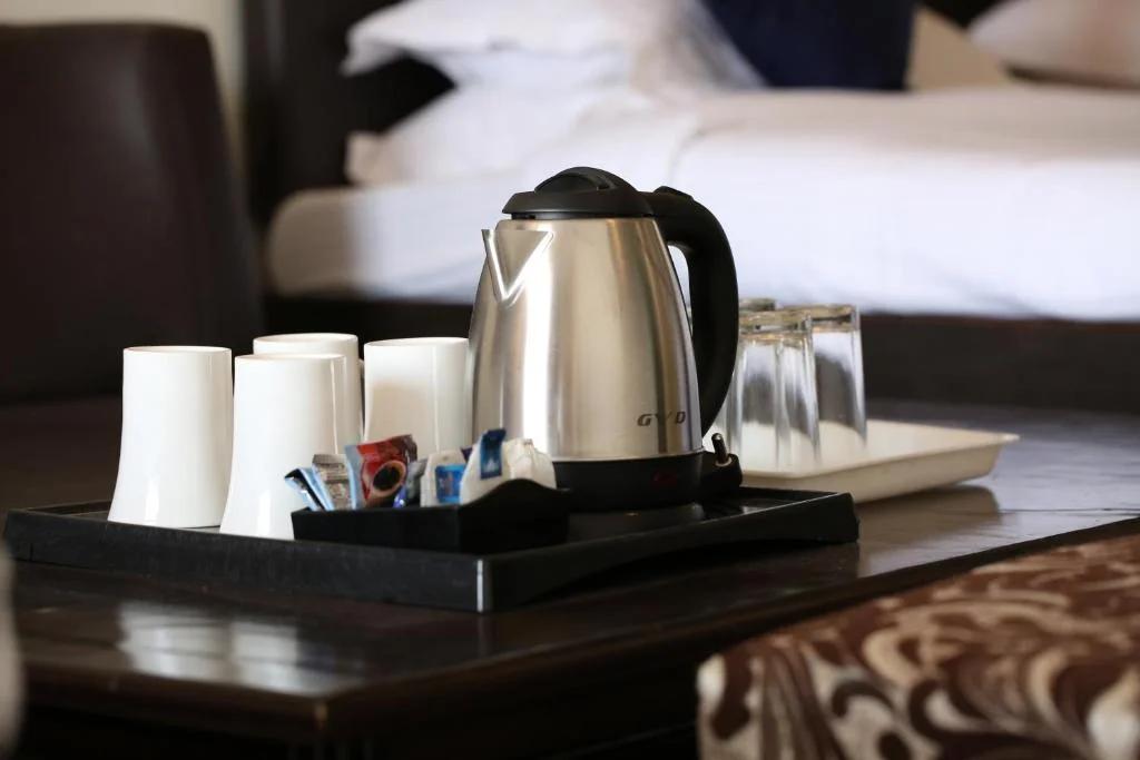 a double bed with sofa at ceyone classic fall in mussoorie hotel_Image