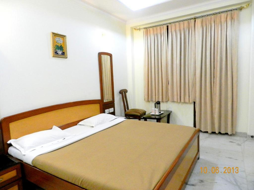 a bedroom with a large bed and a sofa at hotel tara palace chandni chowk in New Delhi hotel_Image