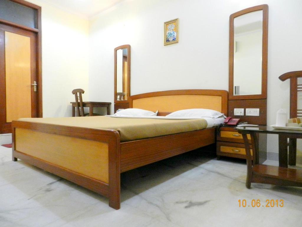 a bedroom with a large bed and a sofa at hotel tara palace chandni chowk in New Delhi hotel_Image