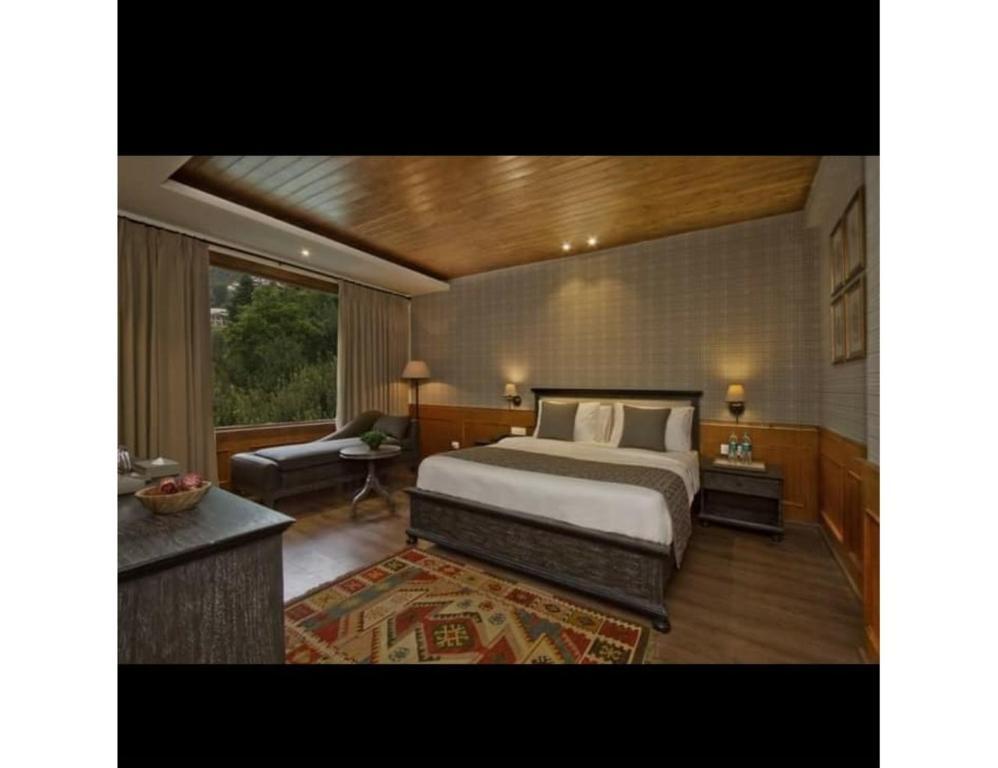 a bedroom with a large bed and a sofa at staybook hotel usha palace in Mussoorie hotel_Image