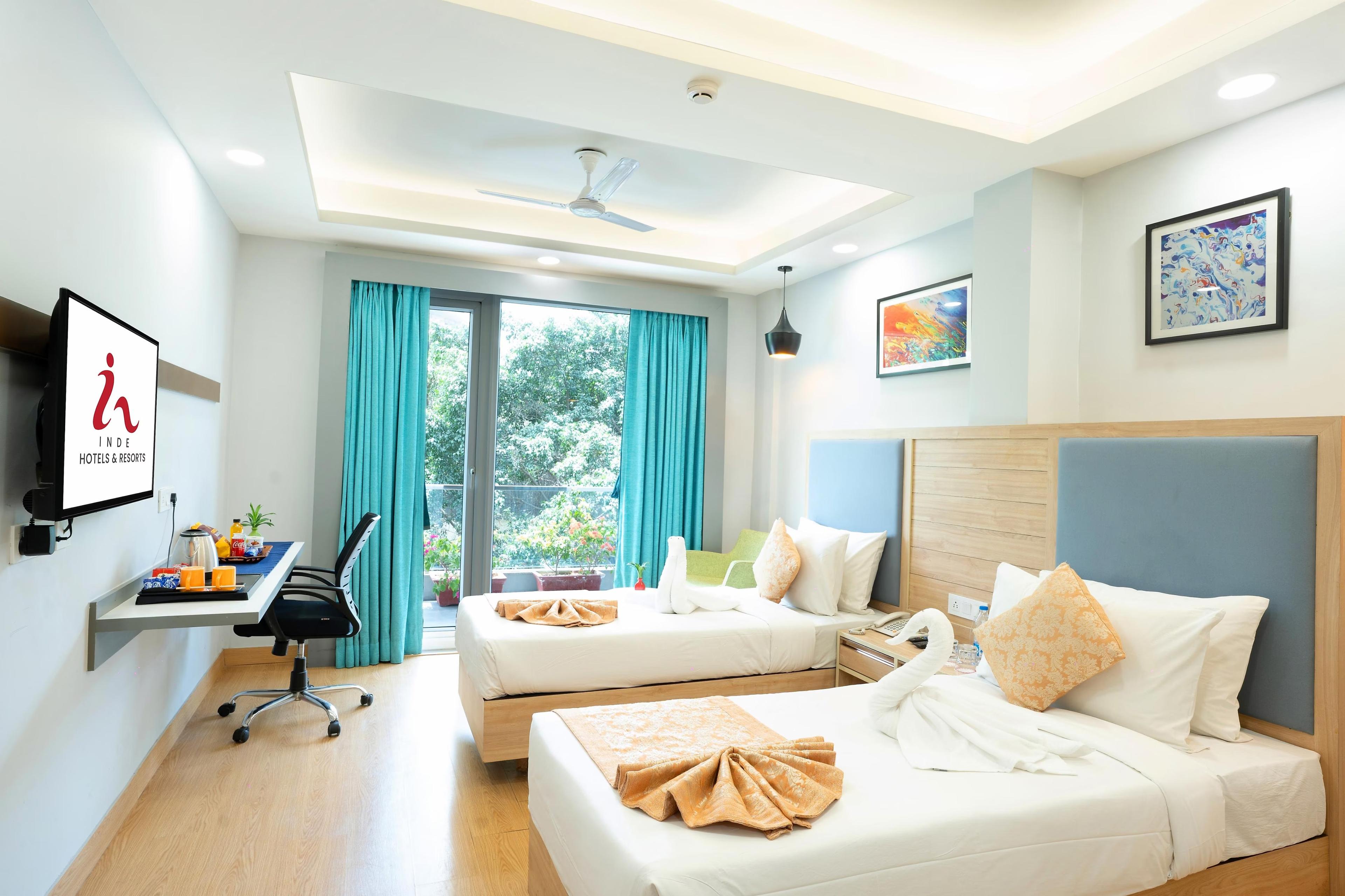 a bedroom with two single bed and a tv at Inde Hotel Golf Course Extn road in Gurugram hotel_Image