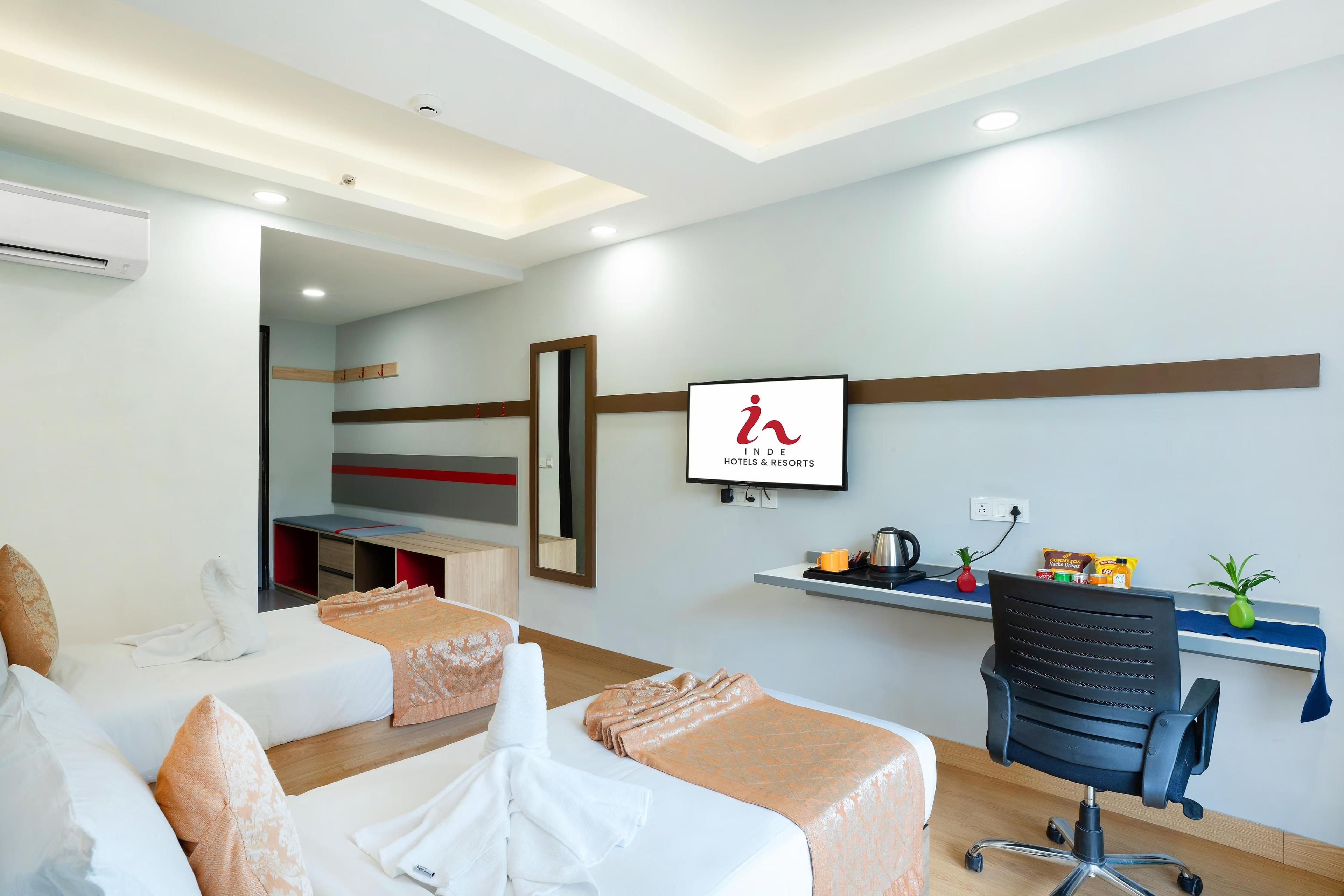 a bedroom with two single bed and a tv at Inde Hotel Golf Course Extn road in Gurugram hotel_Image