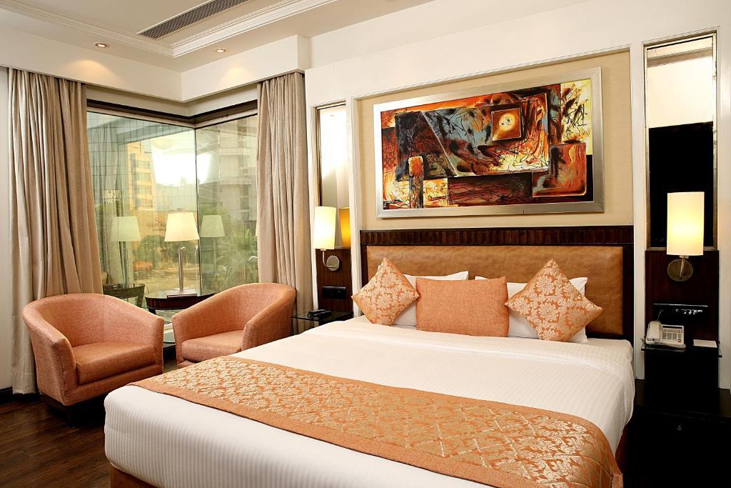 a bedroom with a large bed and a sofa at inde hotel signature tower in gurugram hotel_Image