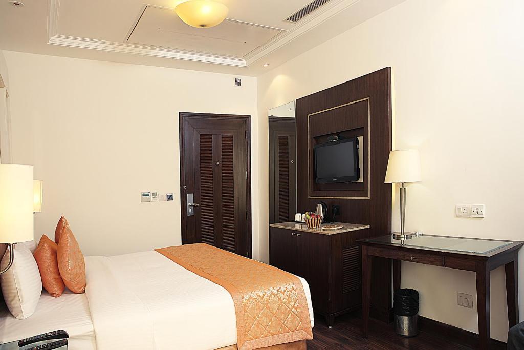 a bedroom with a large bed and a tv at inde hotel signature tower in gurugram hotel_Image