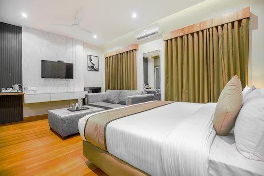 a bedroom with a sofa and a tv at mm hotel in chandigarh hotel_Image