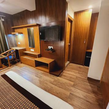 a bedroom with a sofa and a tv at mm hotel in mussoorie hotel_Image