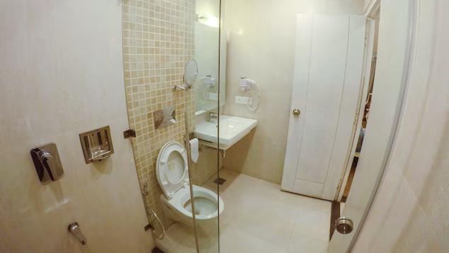 a bathroom with a toilet and a sink at sanobar the midtown hotel in mussoorie hotel_Image