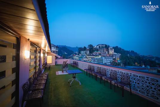 a balcony view of hotel with chairs and table at sanobar the midtown hotel in mussoorie hotel_Image
