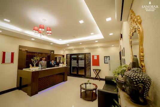 two men stand on reception desk with sofa and table at sanobar the midtown hotel in mussoorie hotel_Image