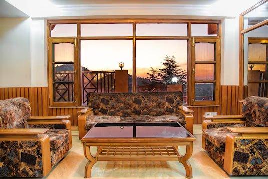 a meeting area with sofa and table at shimla nature ville in shimla hotel_Image