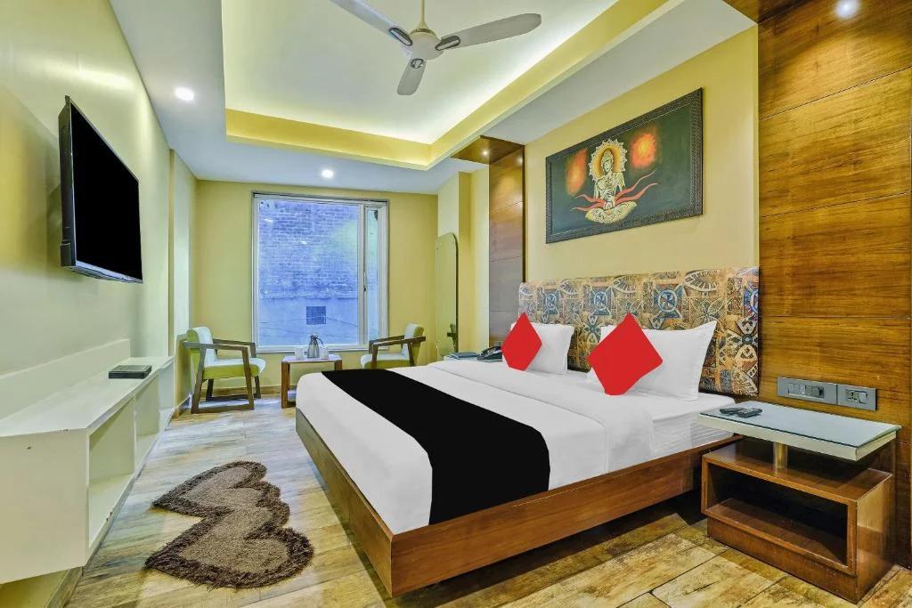 a bedroom with a large bed and sofa at nitya maharani in new delhi hotel_Image