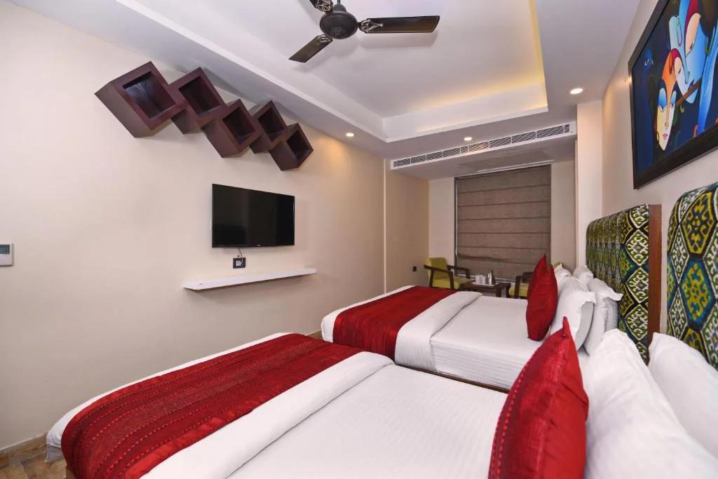 a bedroom with a large bed and sofa at nitya maharani in new delhi hotel_Image