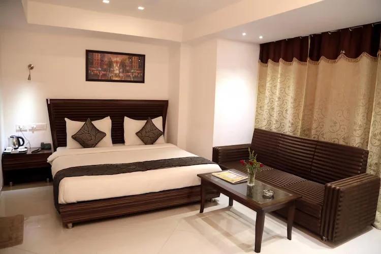 a bedroom with a large bed and sofa at the grand radiant in lucknow hotel_Image