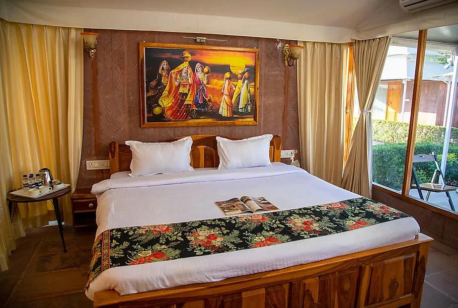 a bedroom with a large bed and window view at kurja resort in jodhpur hotel_Image