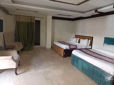 a bedroom with two single bed with sofa and pillows at stay n move in indirapuram hotel_Image